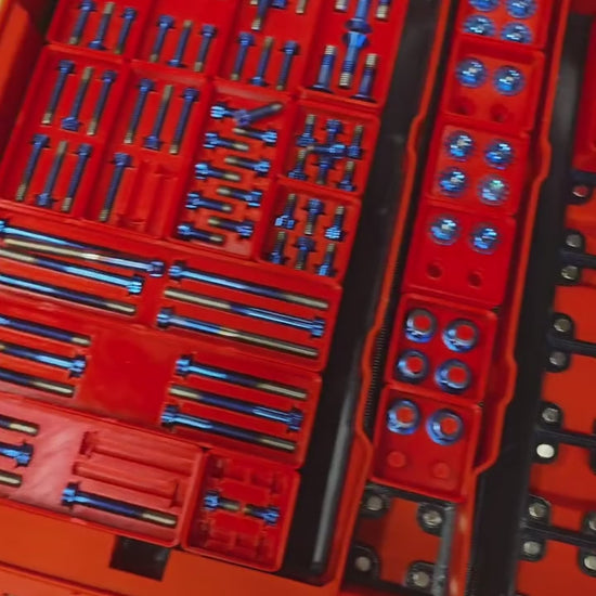 Titanium fasteners in their gridfinity bin cutouts inside Milwaukee Packout organizers
