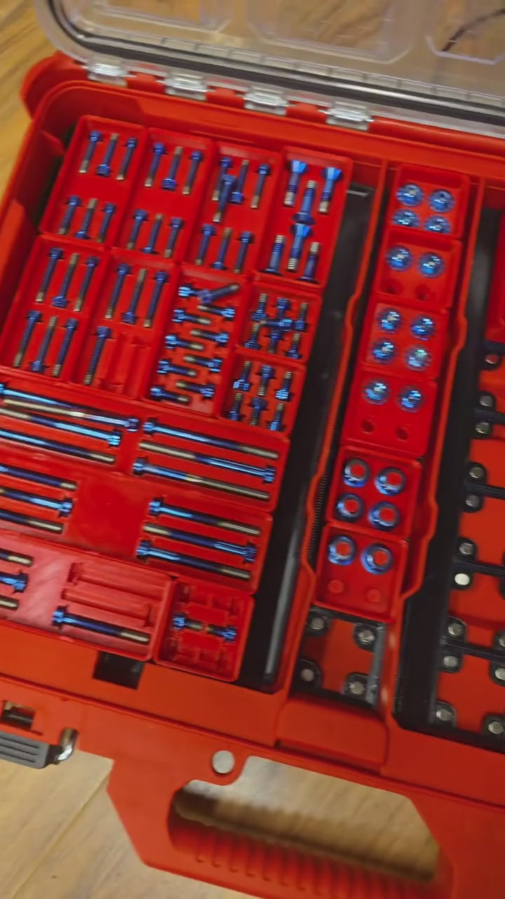 Titanium fasteners in their gridfinity bin cutouts inside Milwaukee Packout organizers